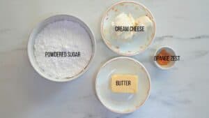 ingredients for making orange cream cheese frosting for the orange rolls
