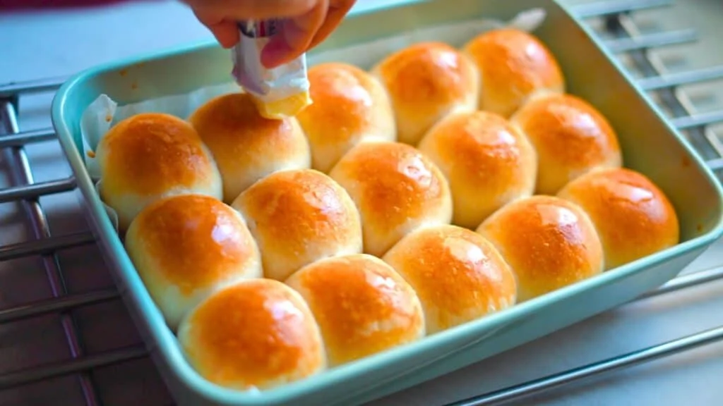 applying butter on sourdough dinner rolls